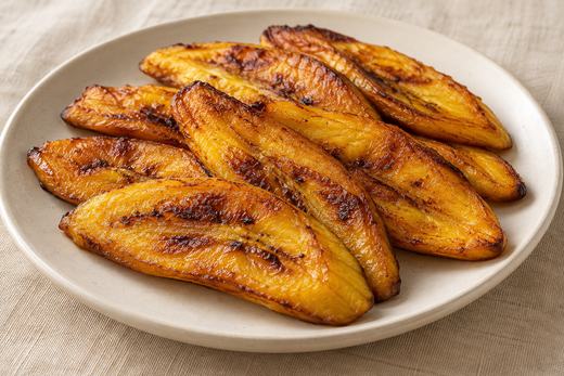 Golden fried ripe plantain slices arranged on a neutral plate